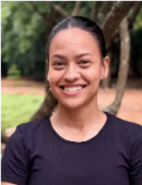 Fredericks, Sandra Sandra Fredericks, with dark hair pulled back, wearing a black shirt, smiles while standing outdoors in front of trees and greenery.